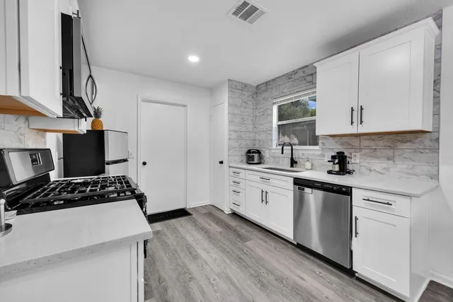 a kitchen with cabinets stove and a sink