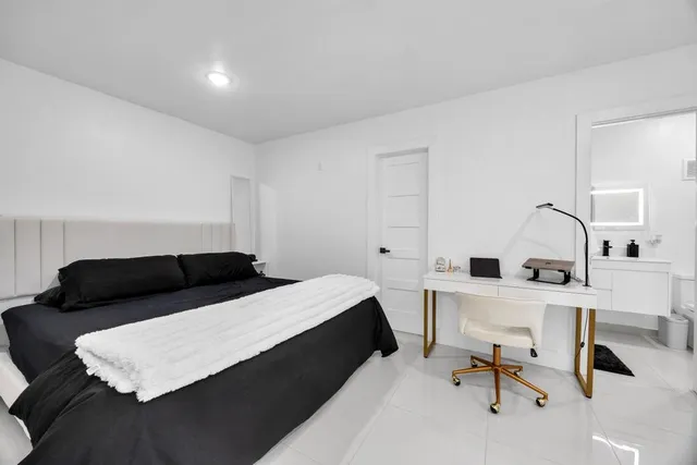 a bedroom with a bed a desk and chair