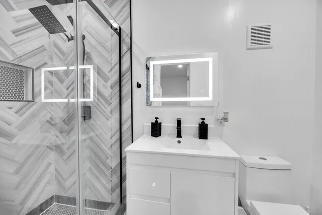a bathroom with a sink and mirror with toilet