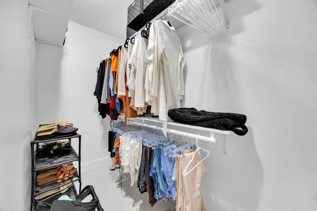 a view of walk in closet with clothes and shoes