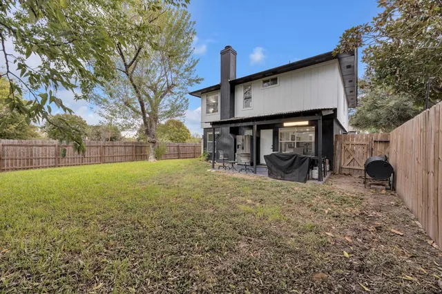 a view of a house with backyard and a tree