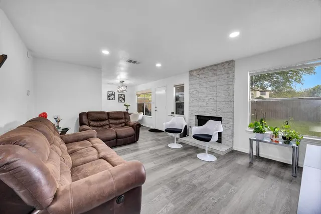 a living room with furniture a fireplace and a floor to ceiling window