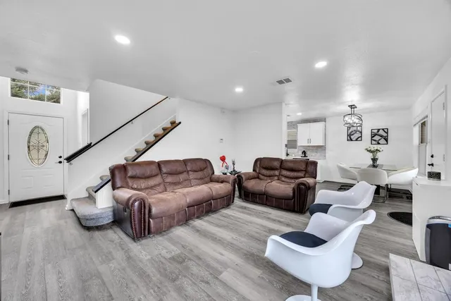 a living room with furniture and a wooden floor
