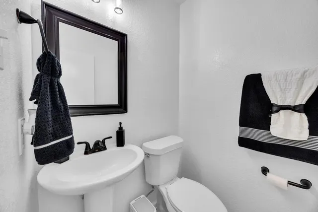 a bathroom with a toilet sink and mirror