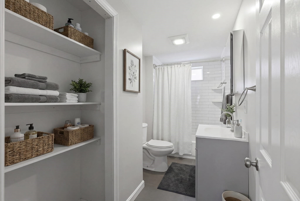 12 Riverside Court Saugus, MA 01906 - Photo 22 of 39 a bathroom with a sink a toilet and shower curtain