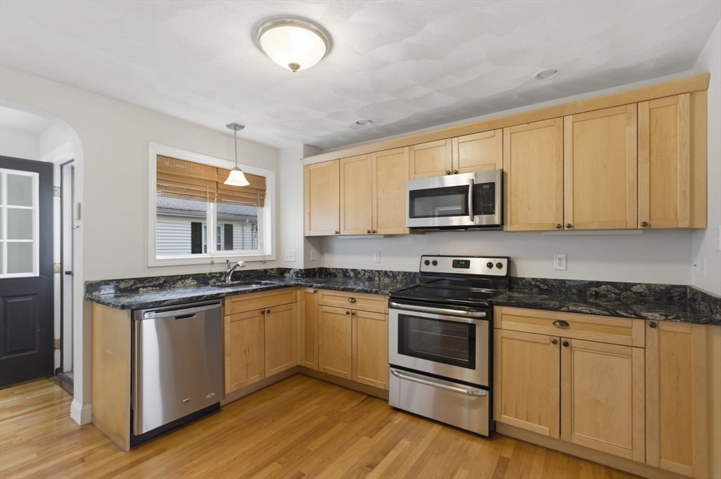 12 Riverside Court Saugus, MA 01906 - Photo 3 of 39 a kitchen with granite countertop a stove top oven sink and cabinets