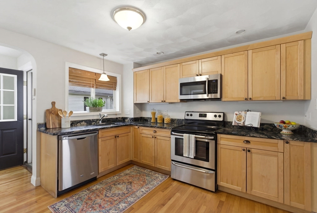 12 Riverside Court Saugus, MA 01906 - Photo 4 of 39 a kitchen with stainless steel appliances granite countertop a stove a sink and a microwave