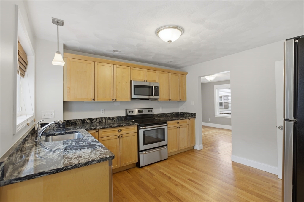 12 Riverside Court Saugus, MA 01906 - Photo 5 of 39 a kitchen with stainless steel appliances granite countertop a stove a sink and a microwave