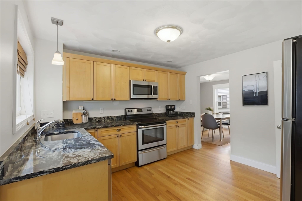 12 Riverside Court Saugus, MA 01906 - Photo 6 of 39 a kitchen with stainless steel appliances granite countertop wooden cabinets a stove top oven a sink and dishwasher