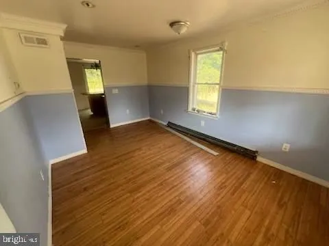 wooden floor in an empty room with a window