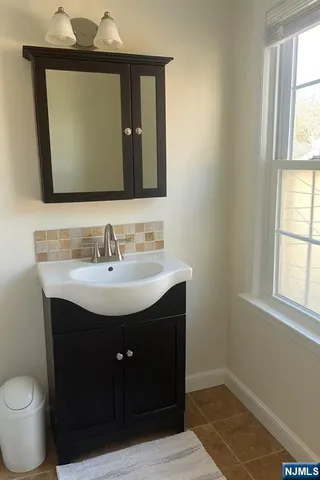 a bathroom with a sink vanity and a mirror