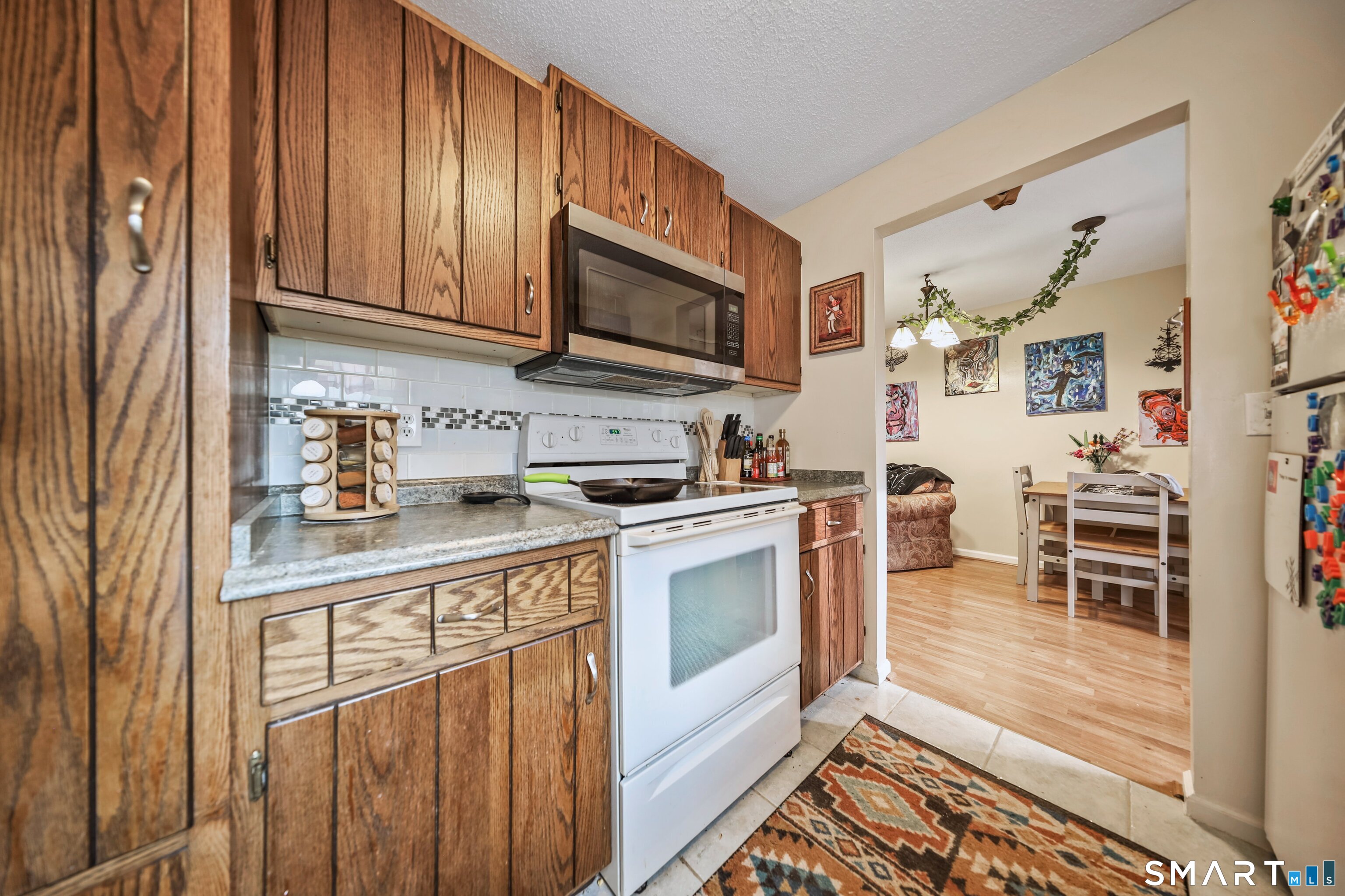 349 Allen Road, Unit 34C Torrington, CT 06790 - Photo 12 of 31 a kitchen with stainless steel appliances granite countertop a stove top oven a sink dishwasher and cabinets with wooden floor