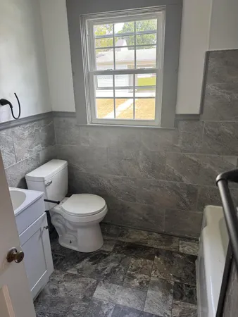 a bathroom with a toilet a sink and a window