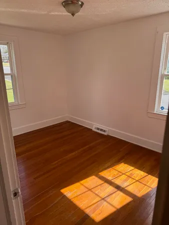 a view of a room with wooden floor and small window