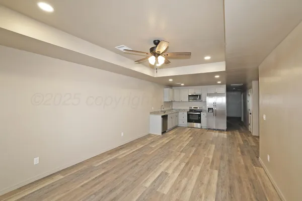 a view of a kitchen with a sink and a refrigerator