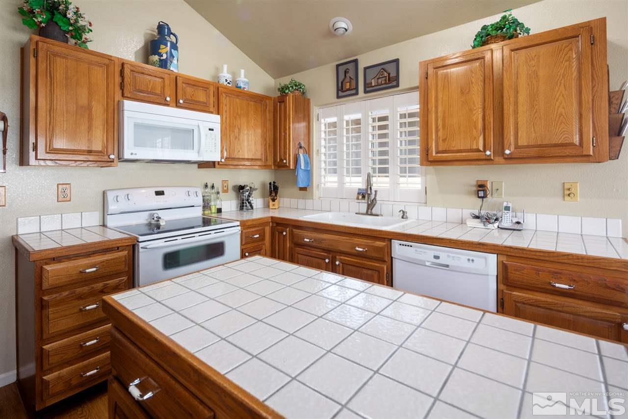 3345 Blackstone Court Reno, NV 89509 - Photo 11 of 29 a kitchen with a sink a stove cabinets and a dining table