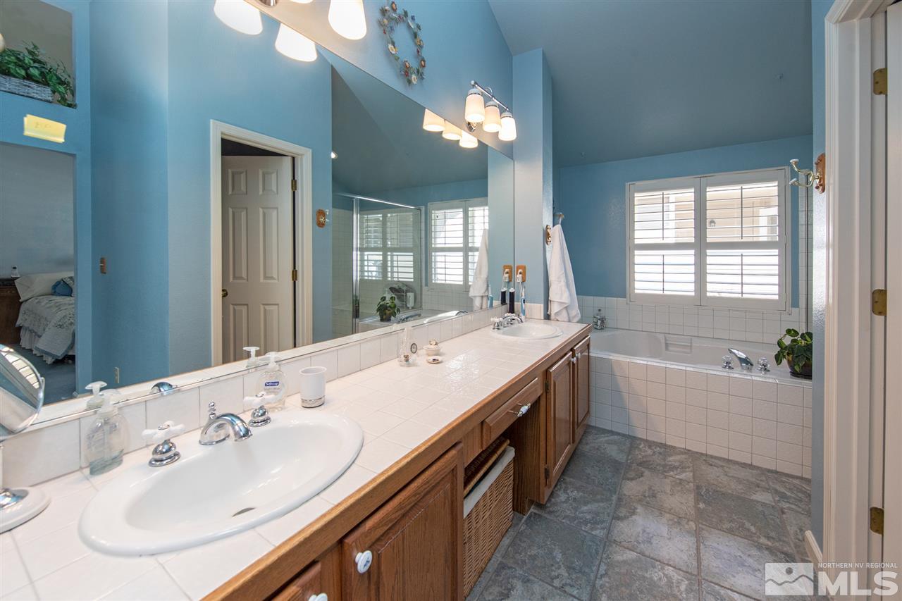 3345 Blackstone Court Reno, NV 89509 - Photo 17 of 29 a spacious bathroom with a sink double vanity granite tub shower and a mirror