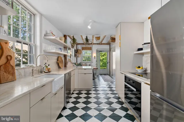 a kitchen with a sink a stove cabinets and a window