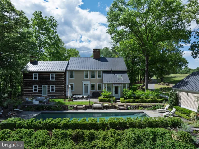 a front view of a house with garden and trees