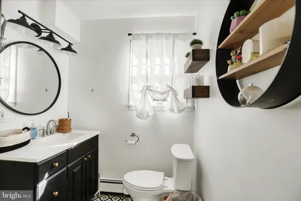 a bathroom with a toilet a sink and mirror