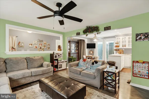 a living room with furniture ceiling fan and a window