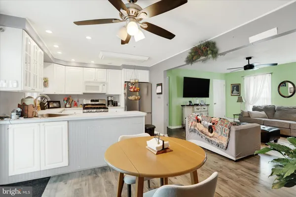 a living room with stainless steel appliances furniture and a flat screen tv