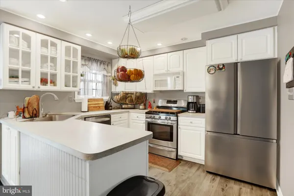 a kitchen with stainless steel appliances a refrigerator a stove a sink and a refrigerator