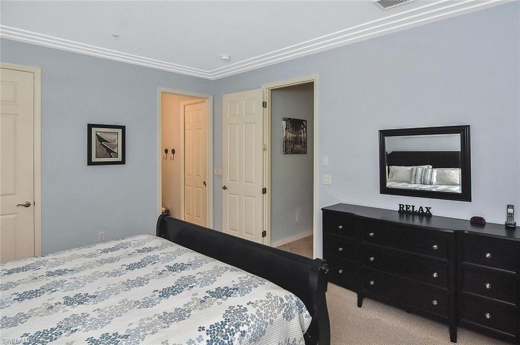 8949 Malibu Street, Unit 303 Naples, FL 34113 - Photo 11 of 50 a bedroom with a bed and a dresser