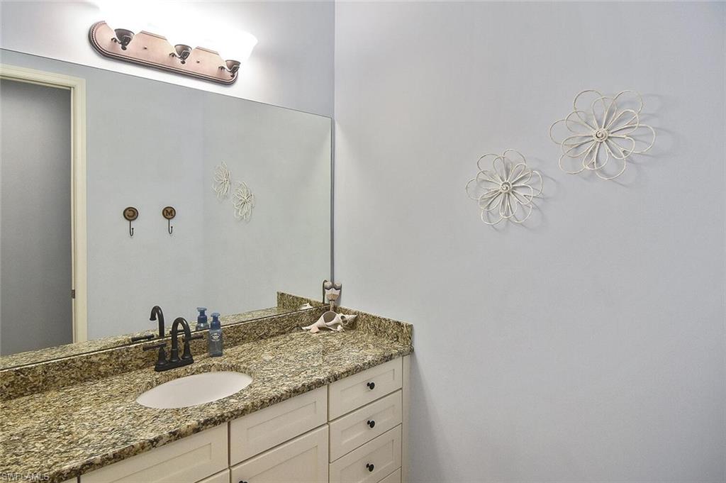 8949 Malibu Street, Unit 303 Naples, FL 34113 - Photo 12 of 50 a bathroom with a granite countertop sink and a mirror