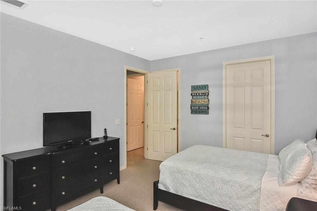 8949 Malibu Street, Unit 303 Naples, FL 34113 - Photo 22 of 50 a bedroom with a bed and a flat screen tv