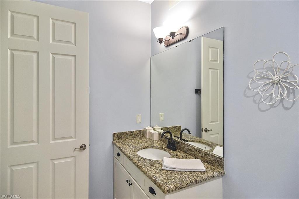 8949 Malibu Street, Unit 303 Naples, FL 34113 - Photo 23 of 50 a bathroom with a granite countertop sink and a mirror