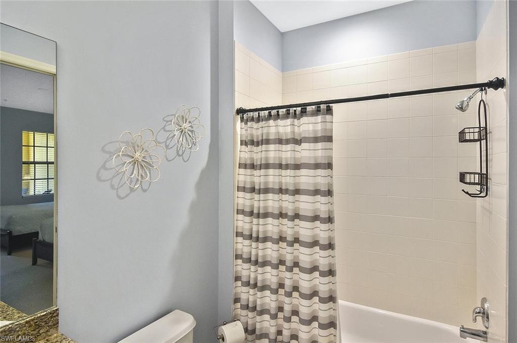 8949 Malibu Street, Unit 303 Naples, FL 34113 - Photo 24 of 50 a bathroom with a shower curtain and a toilet