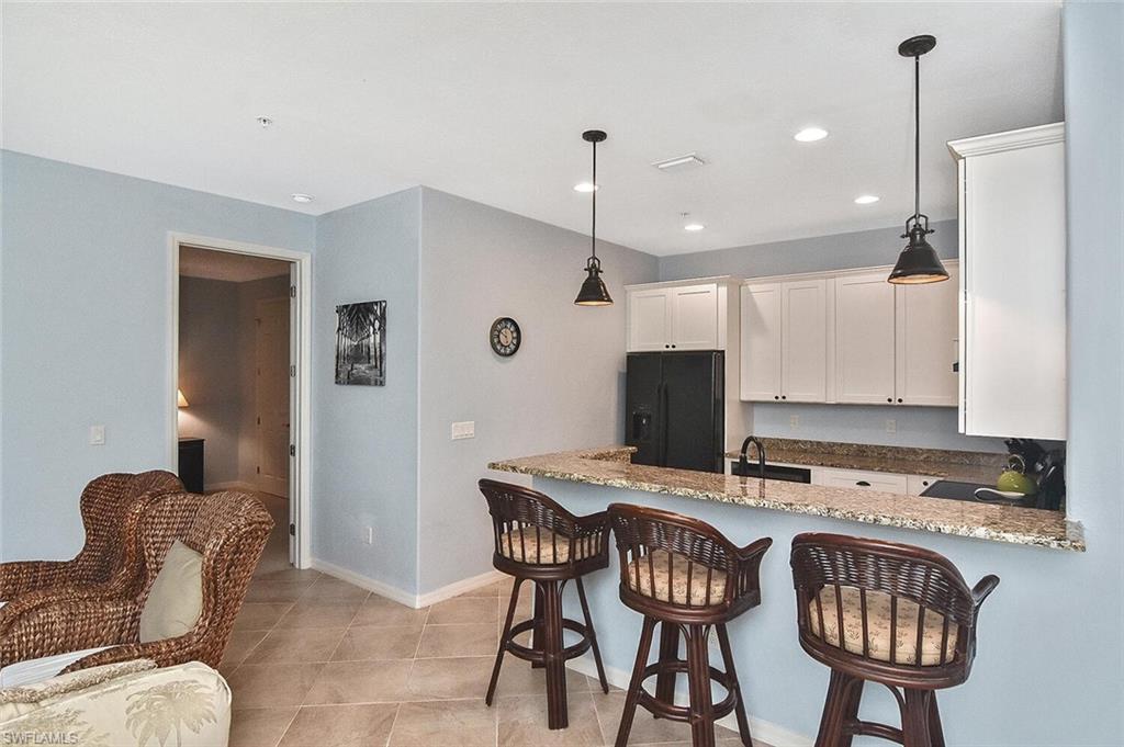8949 Malibu Street, Unit 303 Naples, FL 34113 - Photo 26 of 50 a view of kitchen with granite countertop cabinets table and chairs