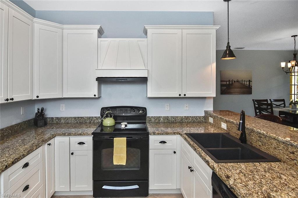 8949 Malibu Street, Unit 303 Naples, FL 34113 - Photo 28 of 50 a kitchen with granite countertop a sink a stove and cabinets