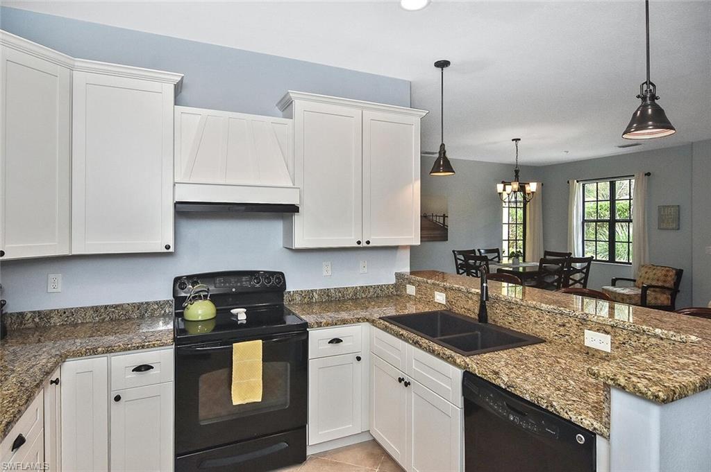 8949 Malibu Street, Unit 303 Naples, FL 34113 - Photo 29 of 50 a kitchen with stainless steel appliances granite countertop a sink a stove and a white cabinets