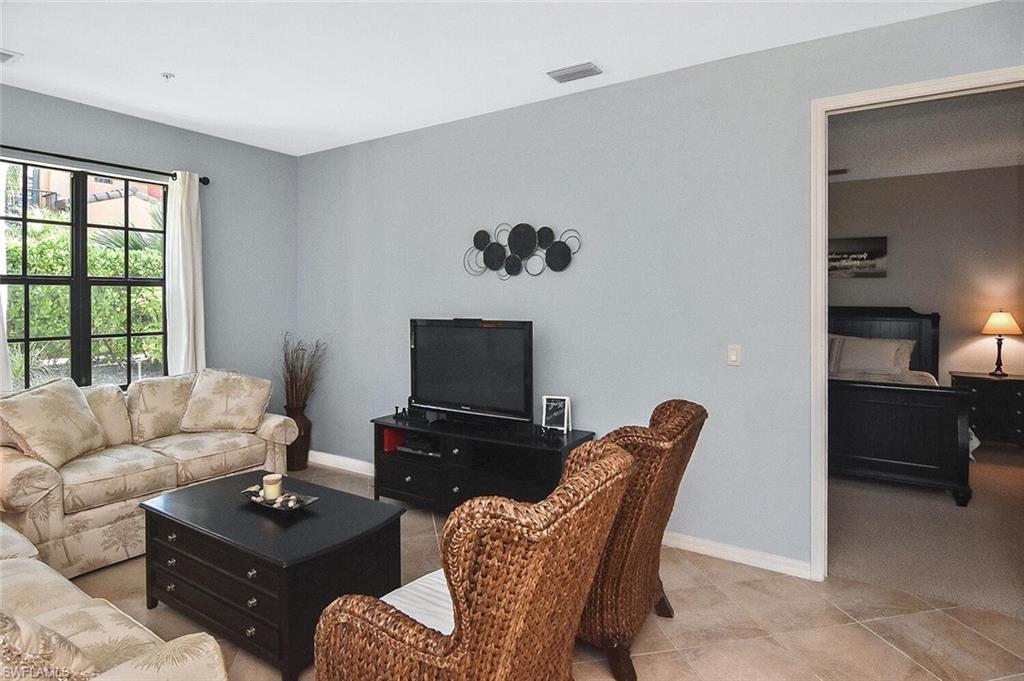8949 Malibu Street, Unit 303 Naples, FL 34113 - Photo 4 of 50 a living room with furniture a flat screen tv and a window