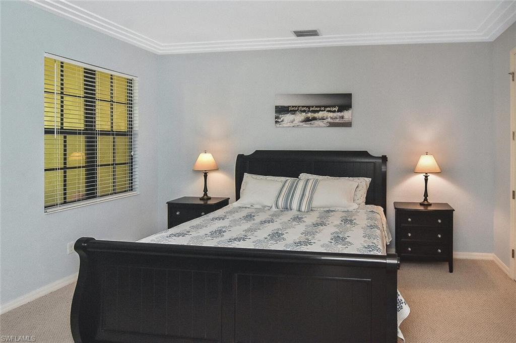 8949 Malibu Street, Unit 303 Naples, FL 34113 - Photo 5 of 50 a bedroom with a bed and a lamp next to a window