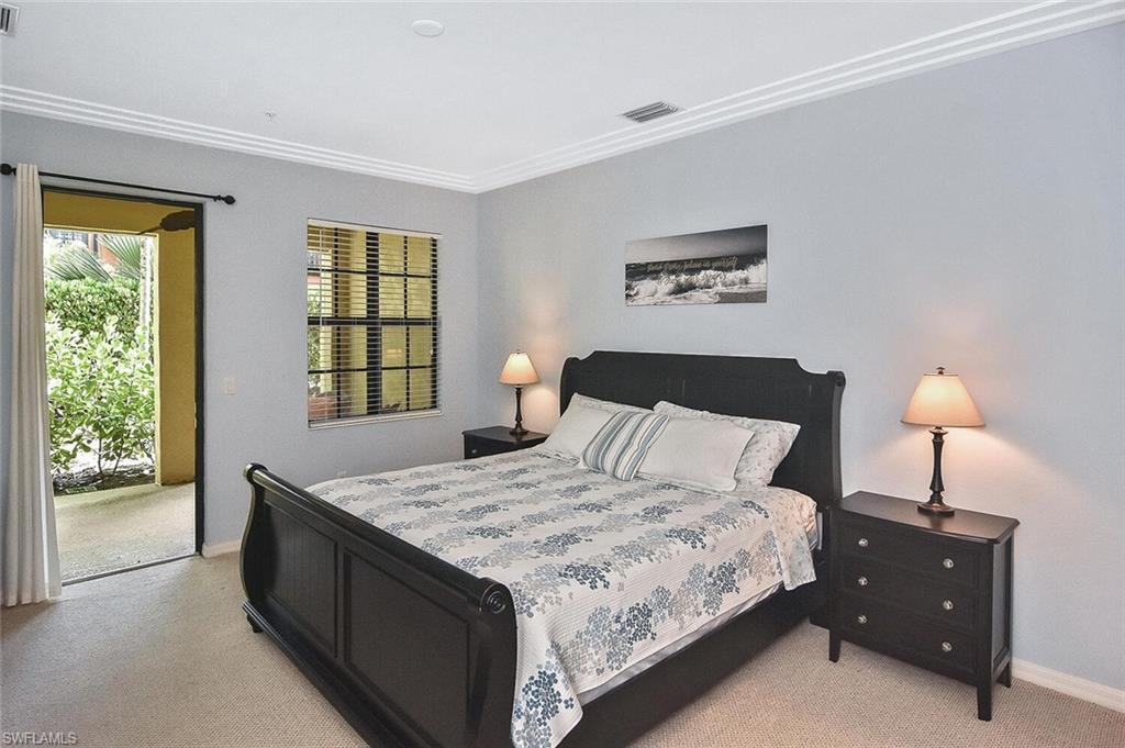 8949 Malibu Street, Unit 303 Naples, FL 34113 - Photo 6 of 50 a bedroom with a bed and a lamp on table