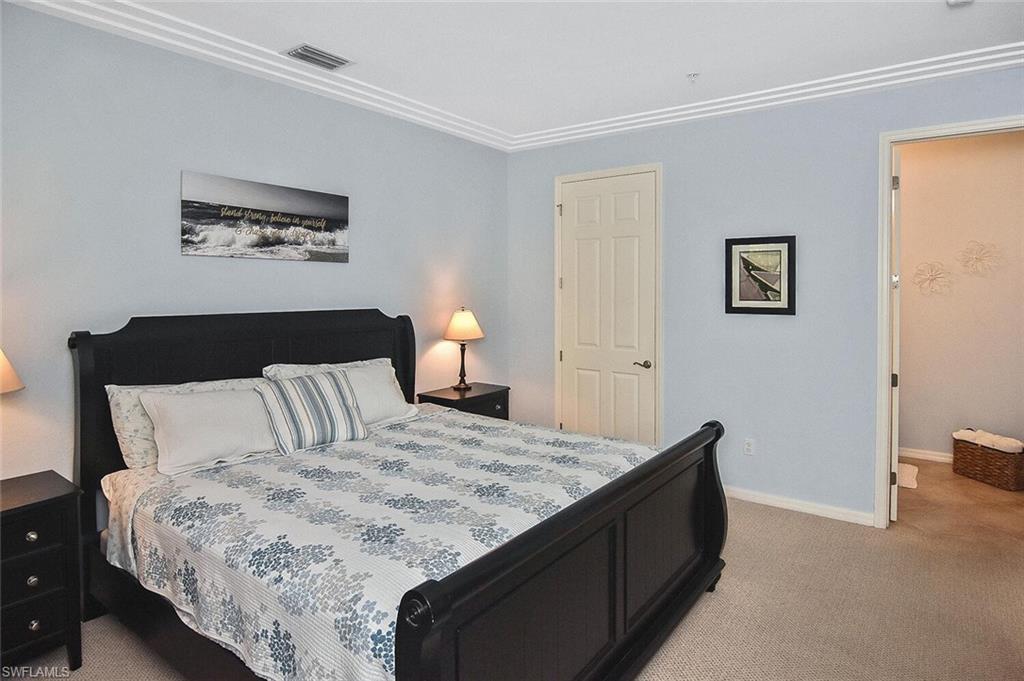 8949 Malibu Street, Unit 303 Naples, FL 34113 - Photo 9 of 50 a bedroom with a bed and a painting on the wall