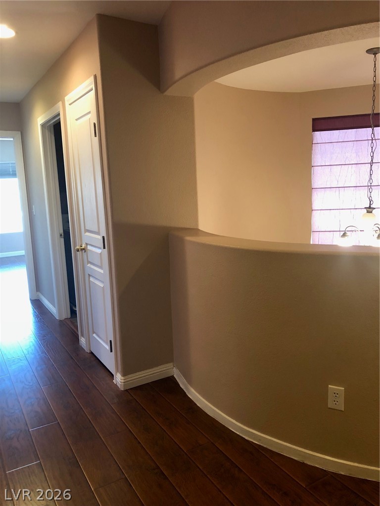 8962 Rutherford Grove Street Las Vegas, NV 89148 - Photo 12 of 16 Upstairs Hallway with dark wood-style flooring and arched walkways