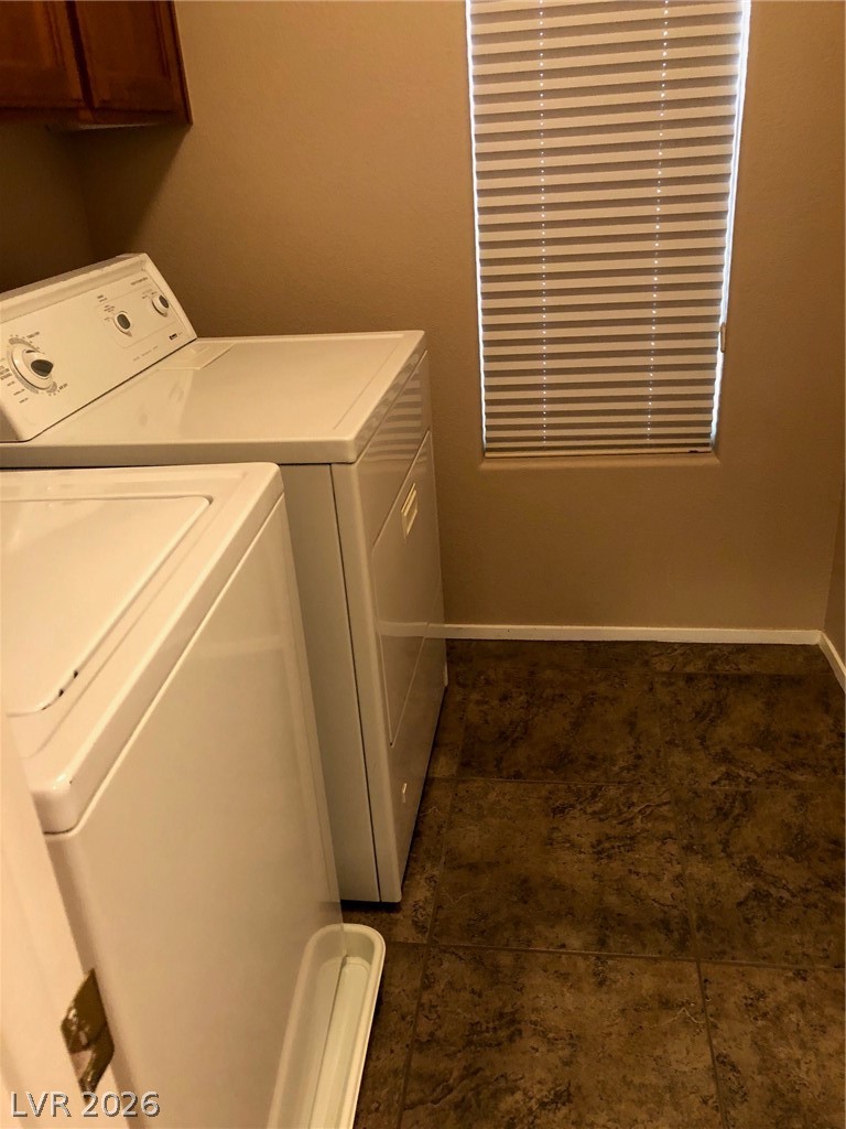 8962 Rutherford Grove Street Las Vegas, NV 89148 - Photo 14 of 16 Laundry area featuring cabinet space, separate washer and dryer, and dark tile patterned flooring