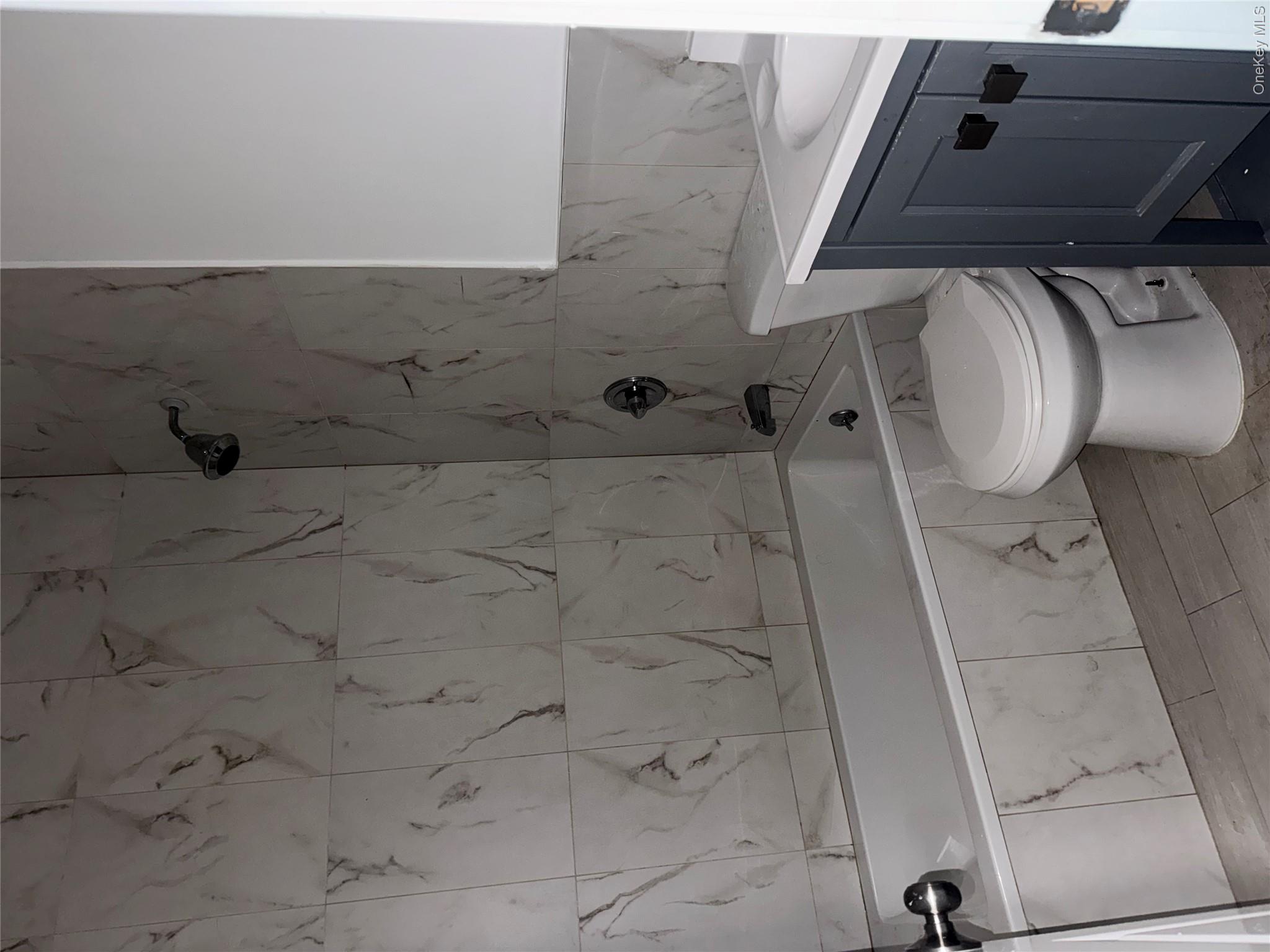 13916 Caney Lane, Unit 2 Queens, NY 11422 - Photo 3 of 9 a bathroom with a sink a toilet and shower