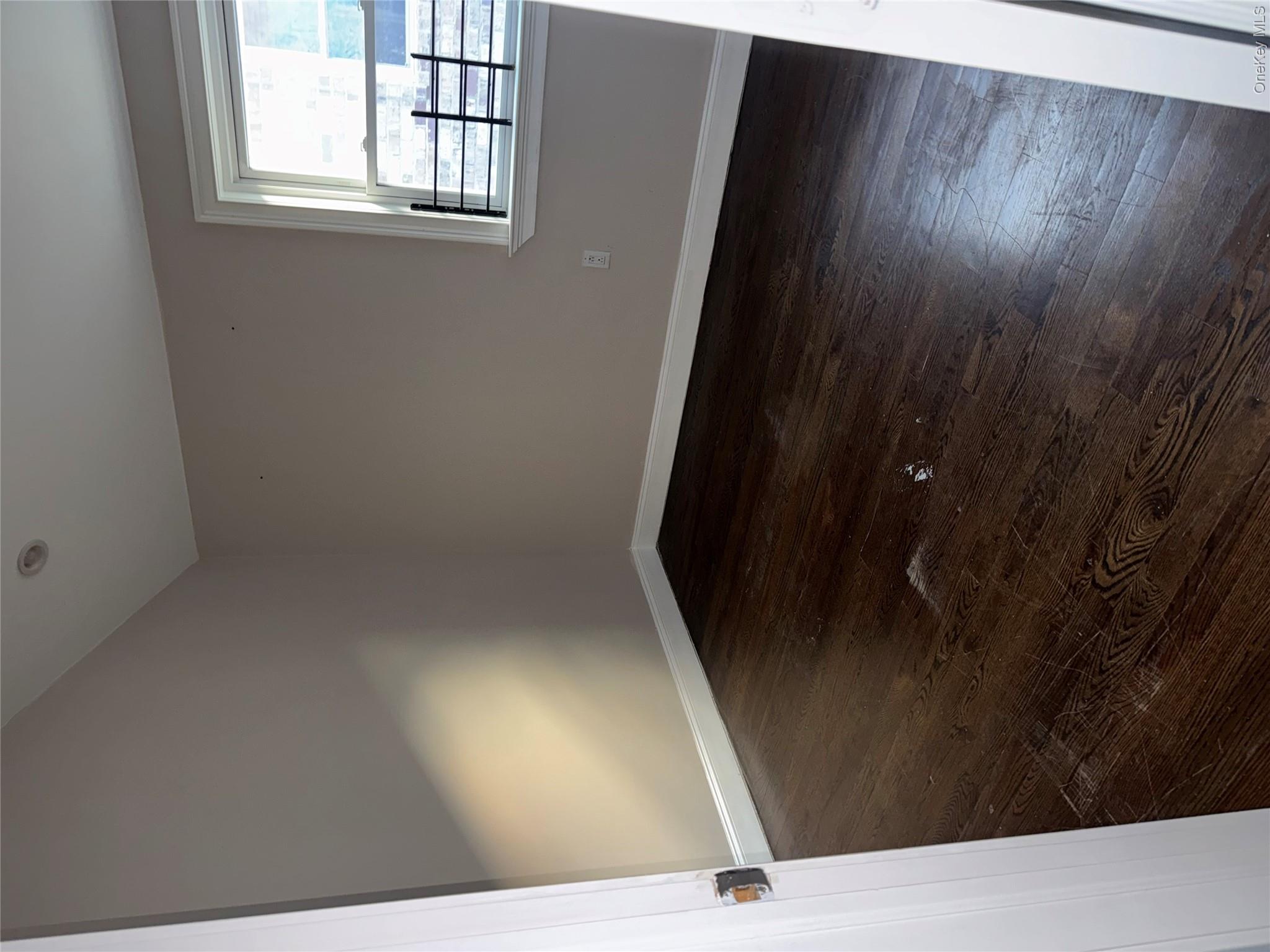 13916 Caney Lane, Unit 2 Queens, NY 11422 - Photo 6 of 9 wooden floor in an empty room with a window