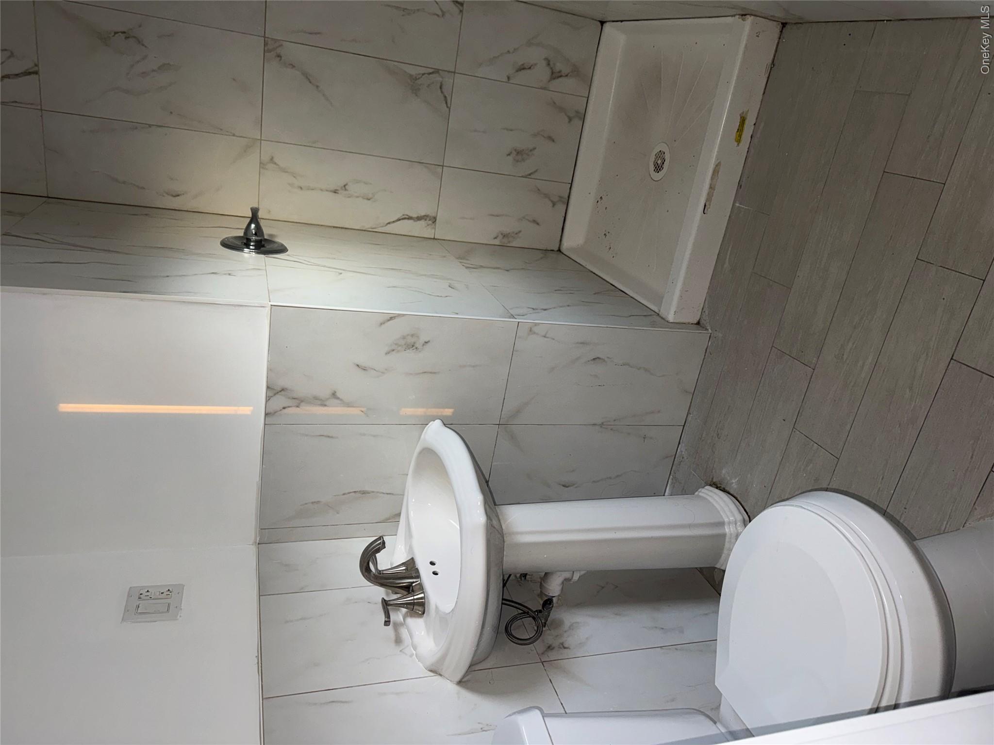 13916 Caney Lane, Unit 2 Queens, NY 11422 - Photo 8 of 9 a bathroom with a sink a toilet and shower