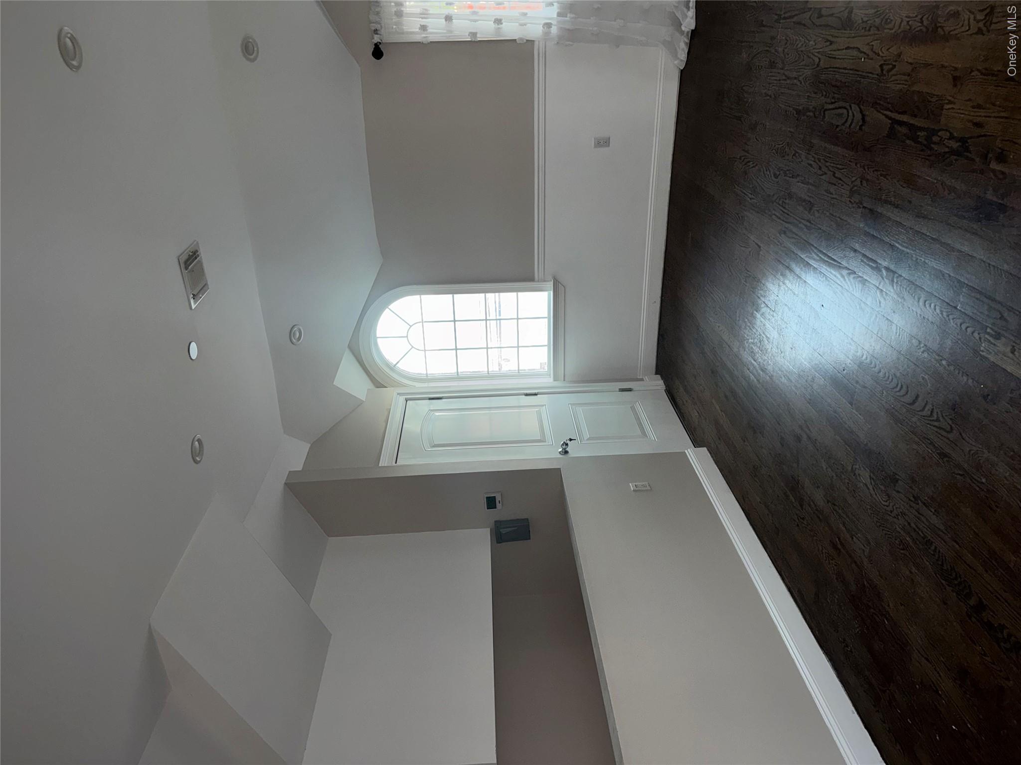 13916 Caney Lane, Unit 2 Queens, NY 11422 - Photo 9 of 9 an empty room with wooden floor and windows