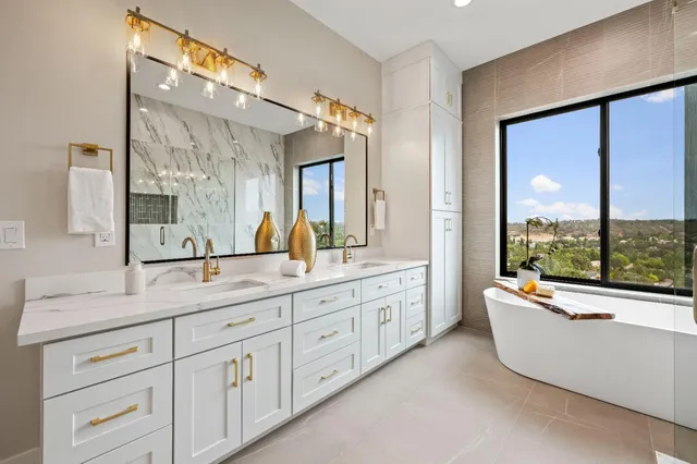 a bathroom with a double vanity sink a mirror and a bathtub