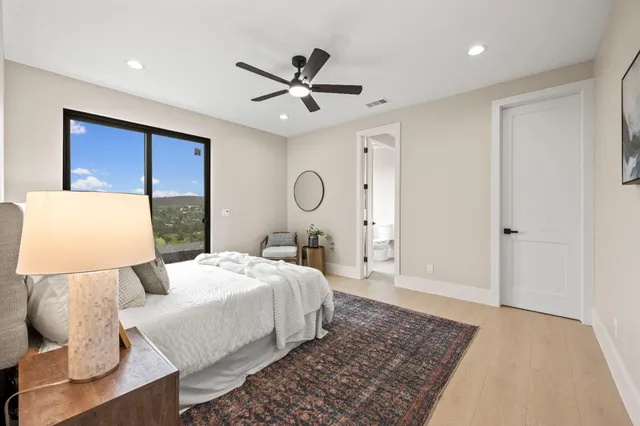 a bedroom with a large bed and a chandelier