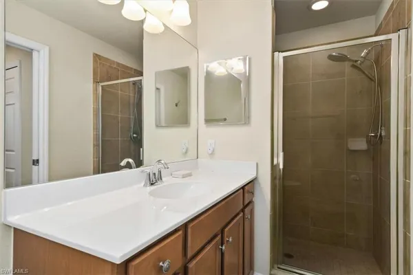 a bathroom with a sink shower and a mirror