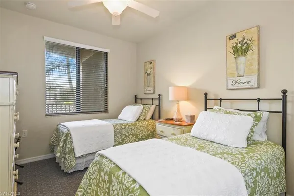 a bedroom with two beds and painting on the wall