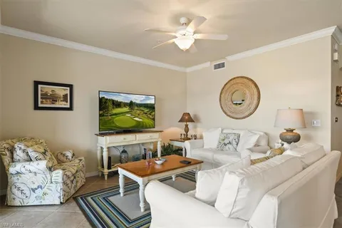 a living room with furniture a clock and a flat screen tv